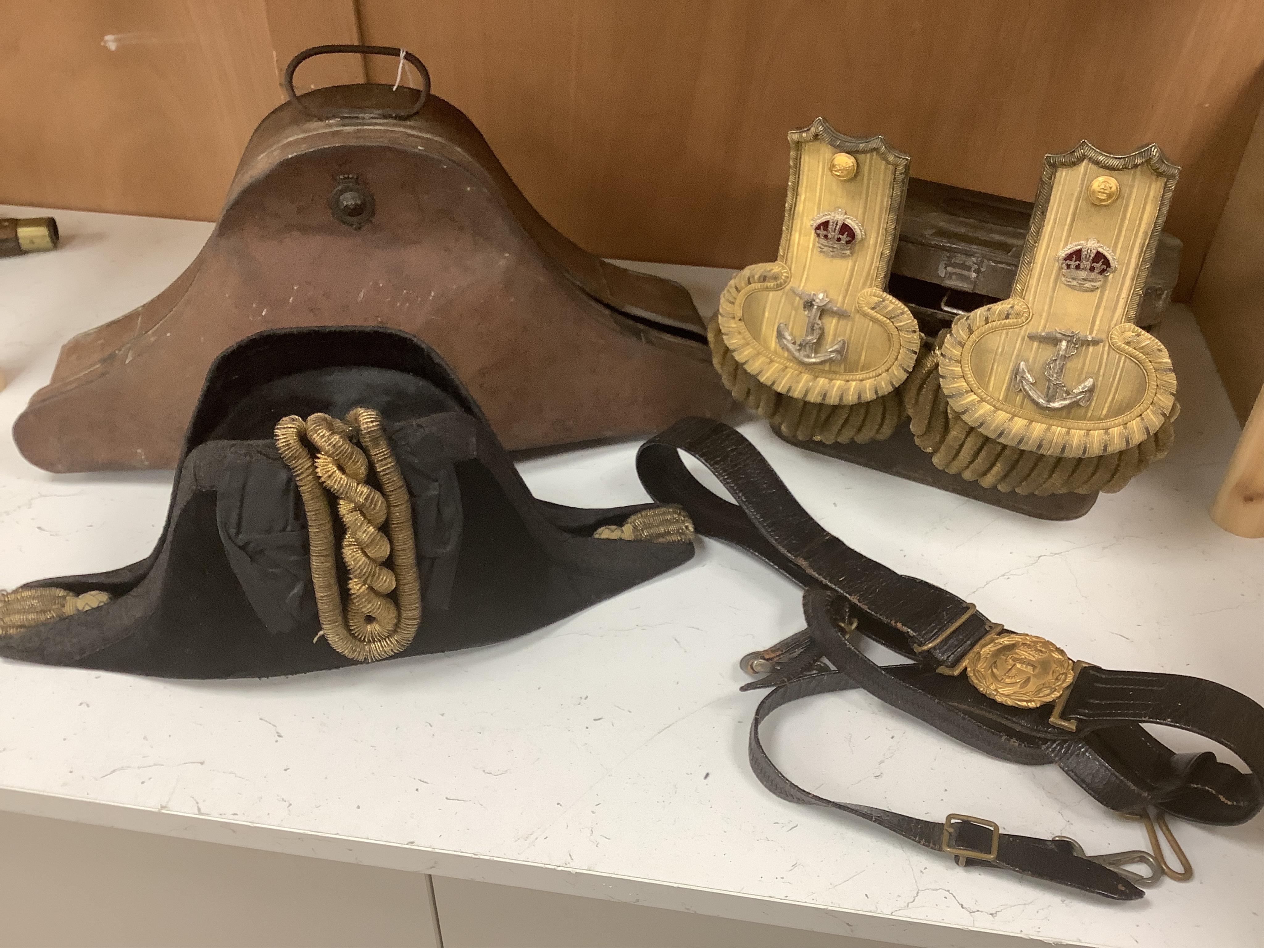 An early 20th century Royal Naval officer’s cased bicorn hat, cased Captain’s bullion work epaulettes and sword hanger, by Gieves and Son